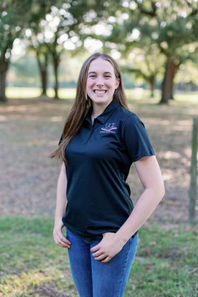 A young woman smiling outdoors in a GCE polo shirt, representing classical Christian homeschool education stages.