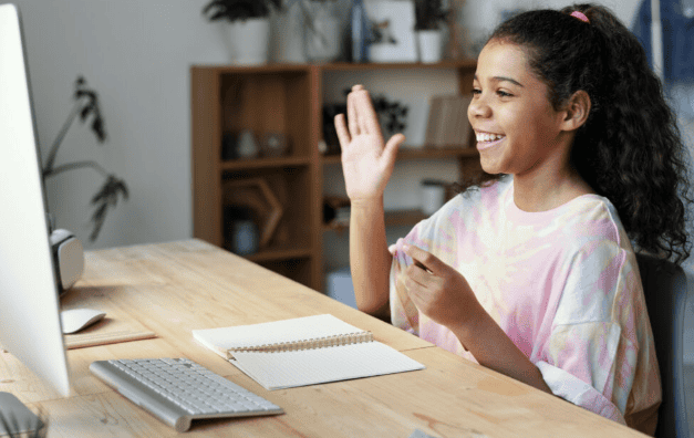 A girl participating in a virtual homeschool class, engaging in a classical education stage via online learning platform.