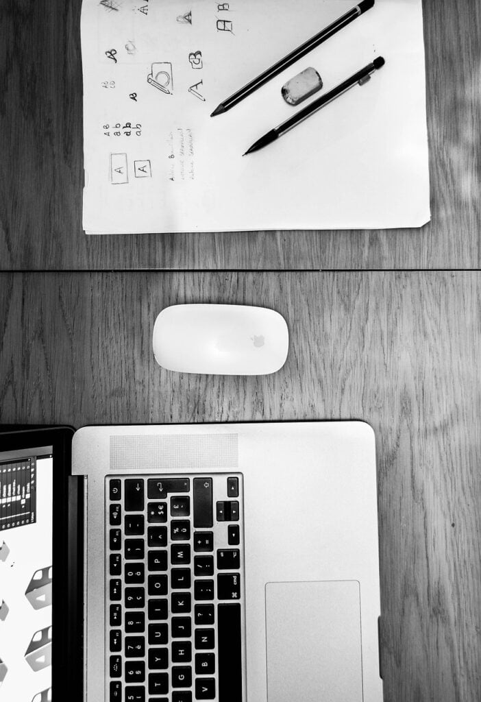 A workspace with educational materials, a laptop, and writing tools for homeschooling students.