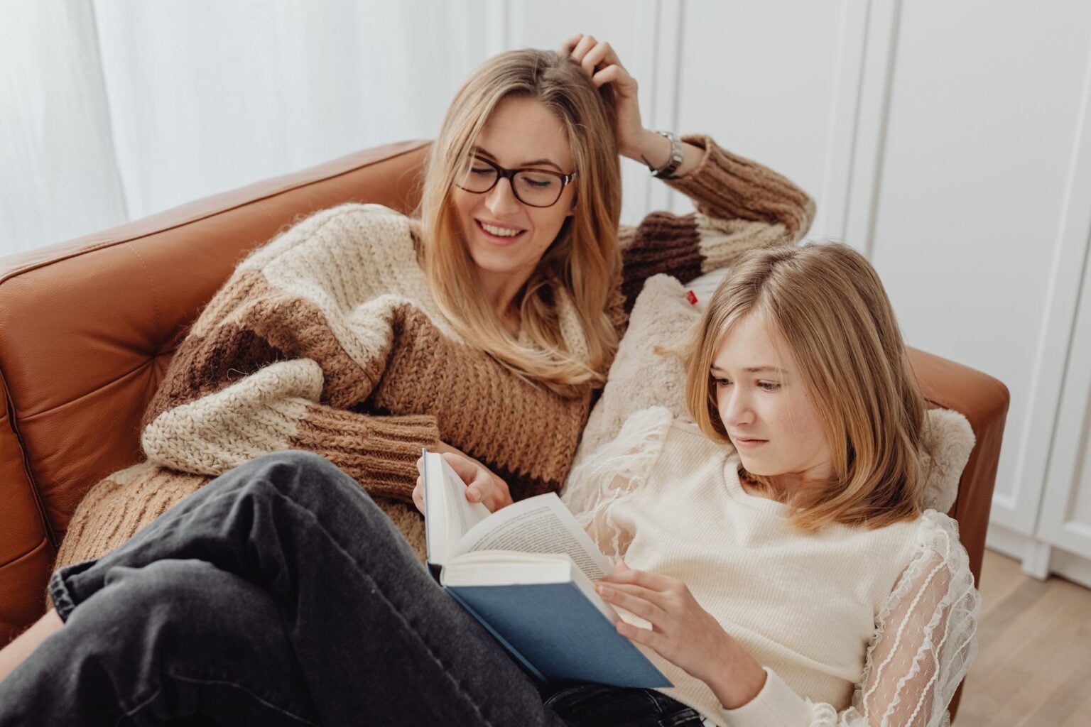 A mother and daughter reading together on the sofa