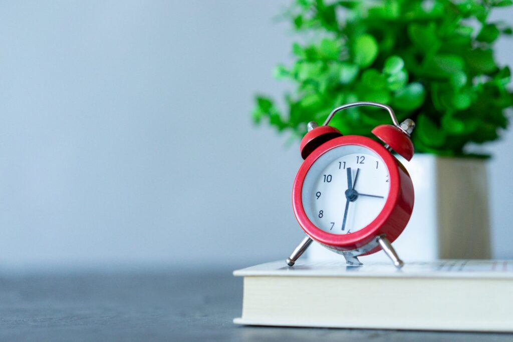 Alarm clock resting on books, a reminder to shorten your homeschool day